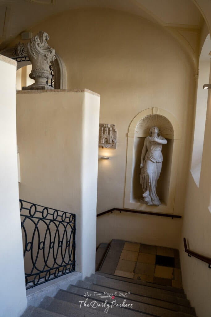 Escalier en pierre historique à l'intérieur de l'Hôtel de Ville de la Vieille Ville de Bratislava avec une statue classique dans une niche murale.