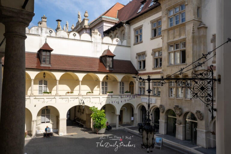 Courtyard of Bratislava Old Town Hall with arched galleries and historic stone details under a blue sky