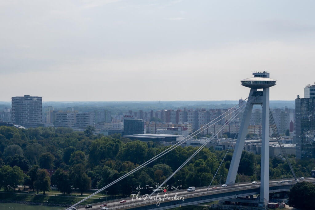 Panoramic view of Bratislava UFO Tower seen from the castle grounds with the Danube River and city in the background.