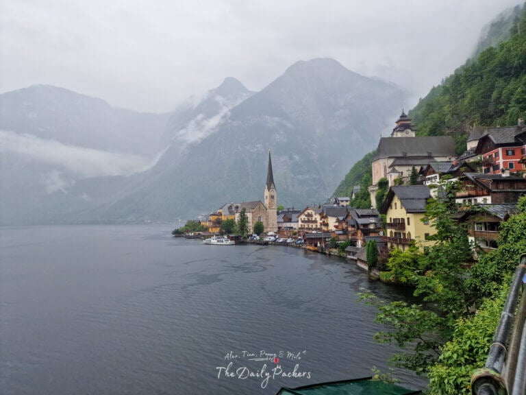 Scenic viewpoint overlooking Hallstatt village and lake under misty mountain clouds