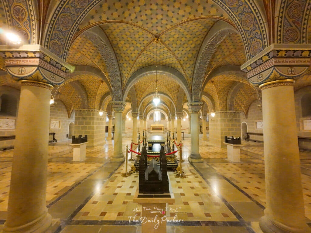 Ornate crypt inside Pécs Cathedral with decorated vaulted ceilings, stone columns, and tombs