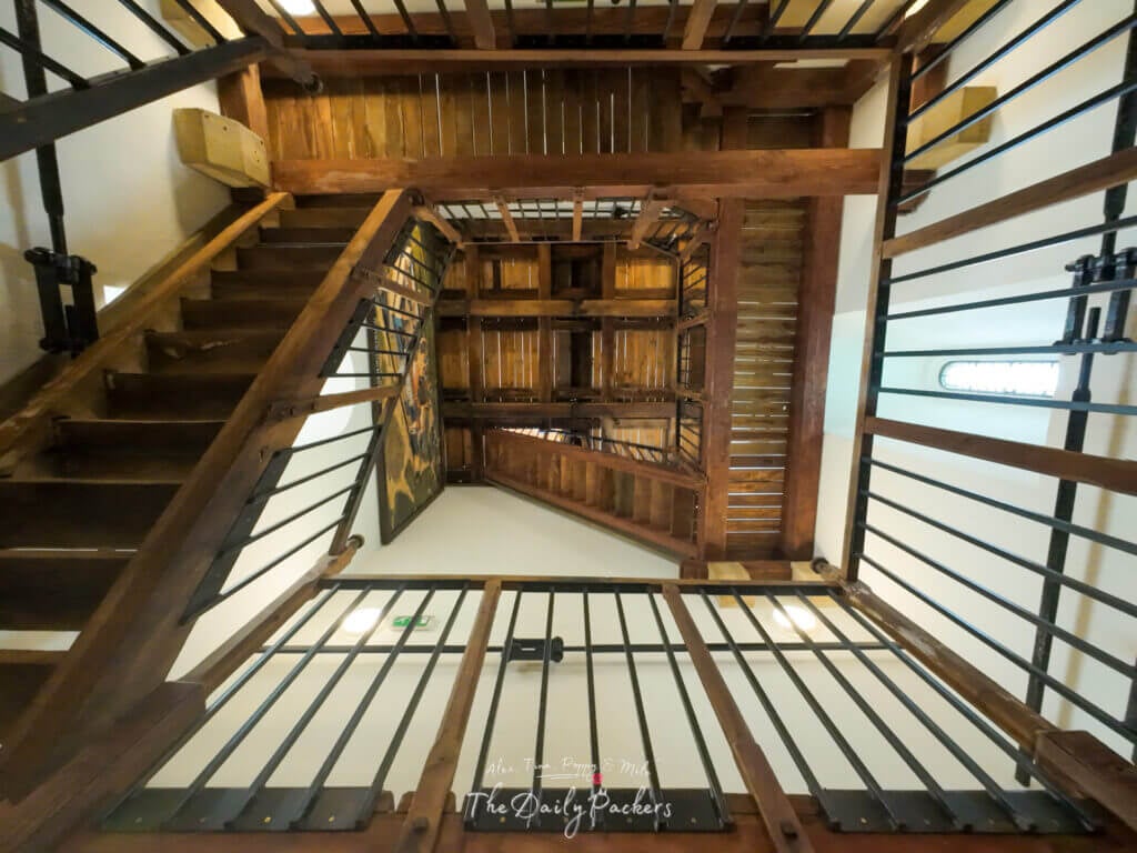 Wooden stairwell inside Pécs Cathedral with multiple levels of stairs and railings seen from below