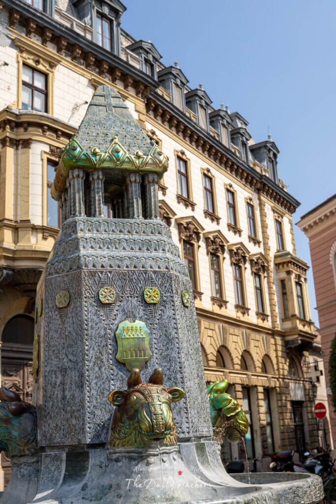 Close-up of the ornate Zsolnay Fountain in Pécs with decorative ceramic bulls and intricate details.