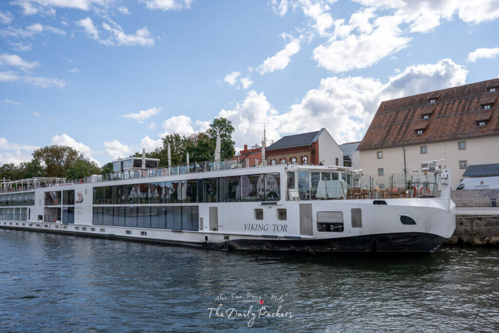 Viking Tor river cruise ship docked in Regensburg along the Danube River with historic buildings in the background.