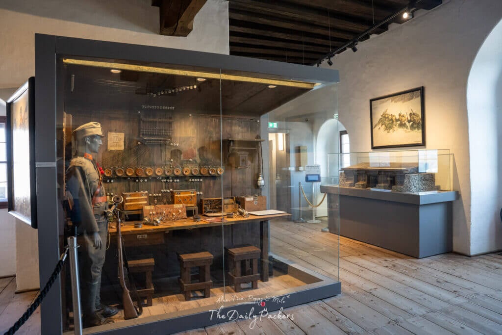 World War I museum display inside Hohensalzburg Fortress with uniform, telecommunication devices, and model.