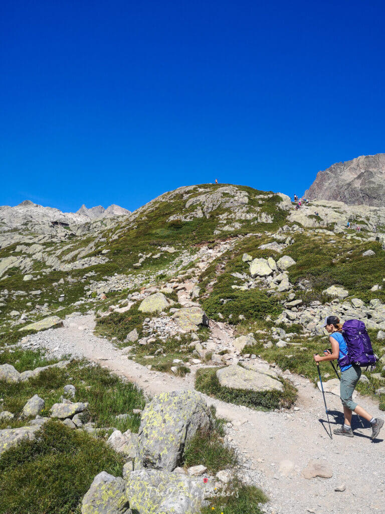 Hiker pushing up a cairned ridge toward the Chéserys lakes