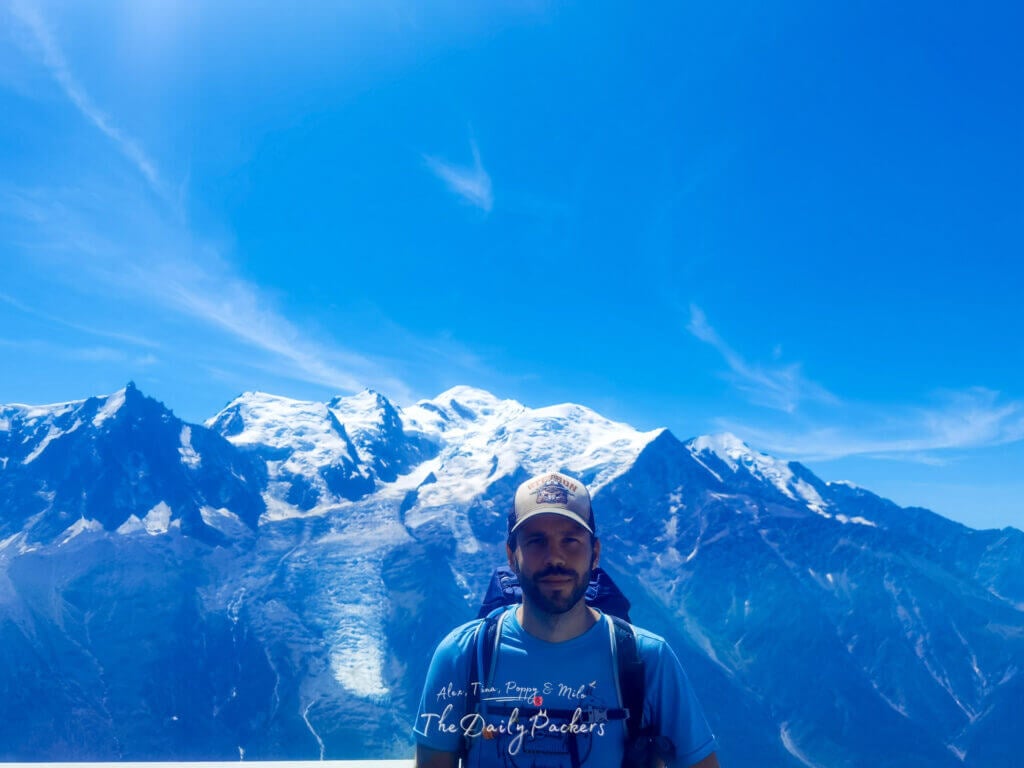 At Brévent viewpoint—man with backpack standing before Mont Blanc during the TMB Stage 11 La Flégère to Les Houches