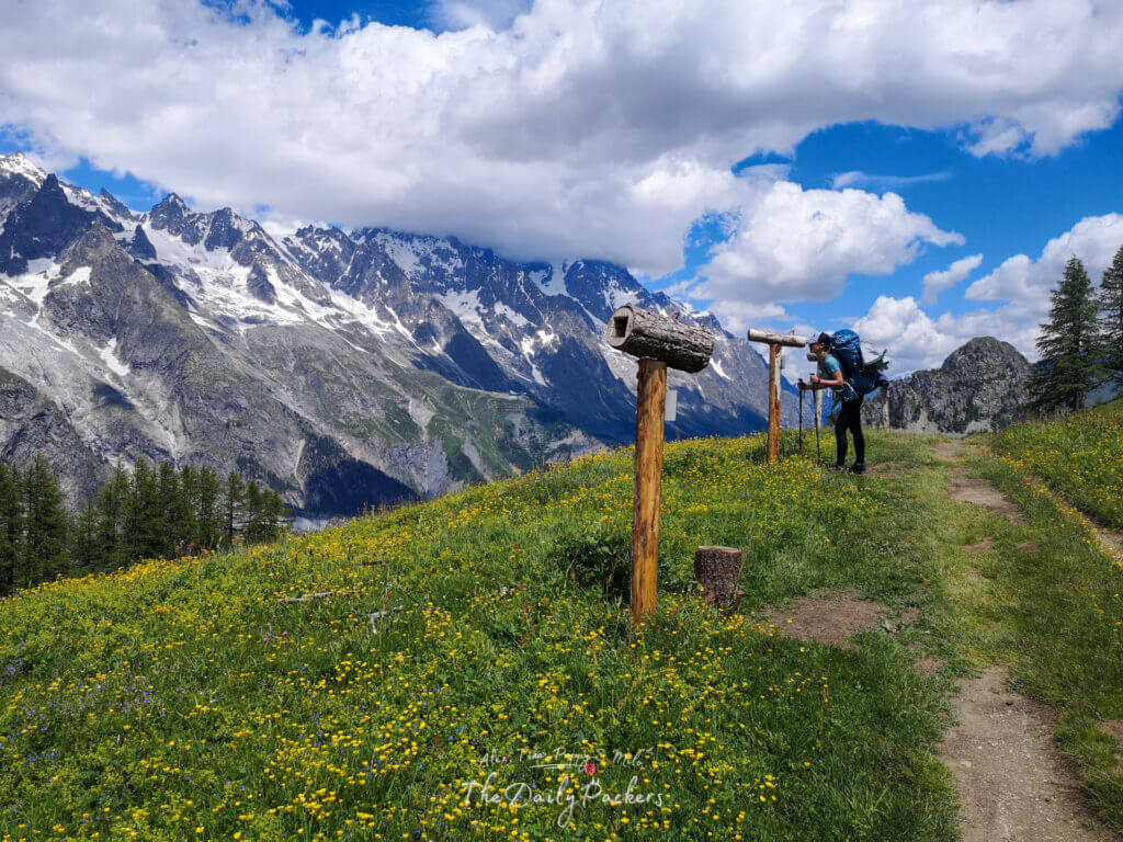 Randonneur regardant à travers un cadre de fenêtre en bois des pics rocheux dramatiques et des glaciers sur l'étape 4 du TMB du refuge Elisabetta à Courmayeur