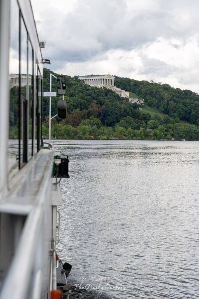 Bateau naviguant sur le Danube avec le monument du Walhalla visible sur la colline au loin.