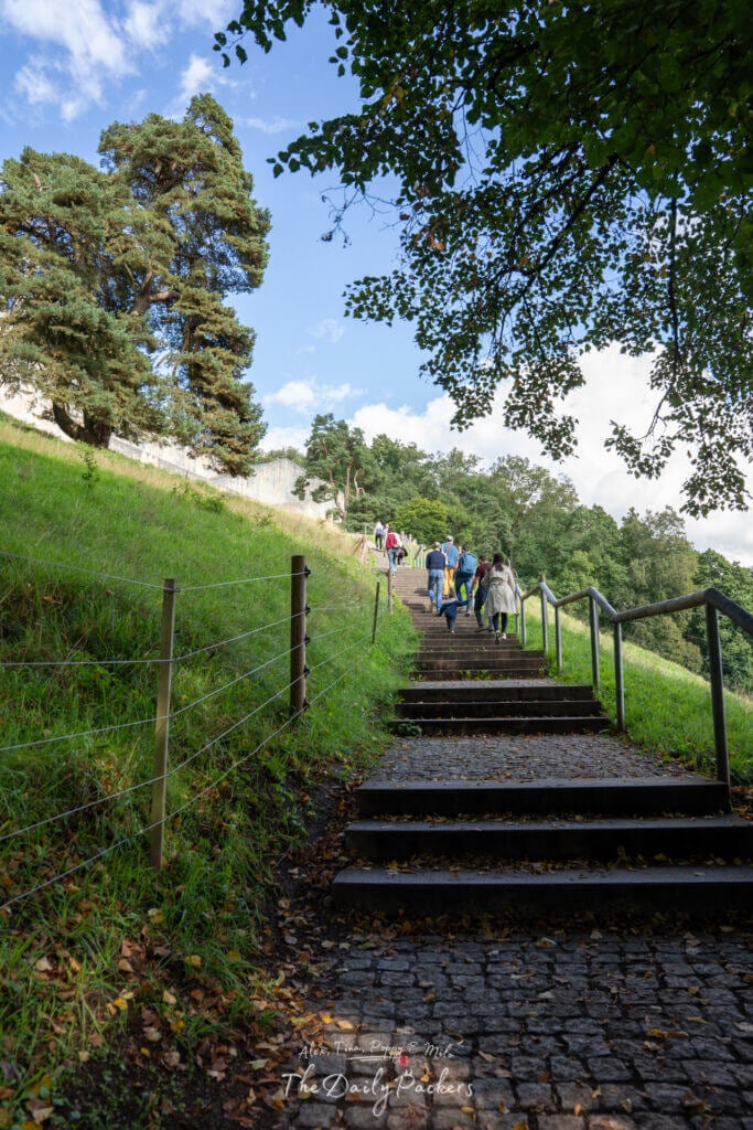 Visiteurs montant l'escalier entouré de verdure en direction du monument du Walhalla.