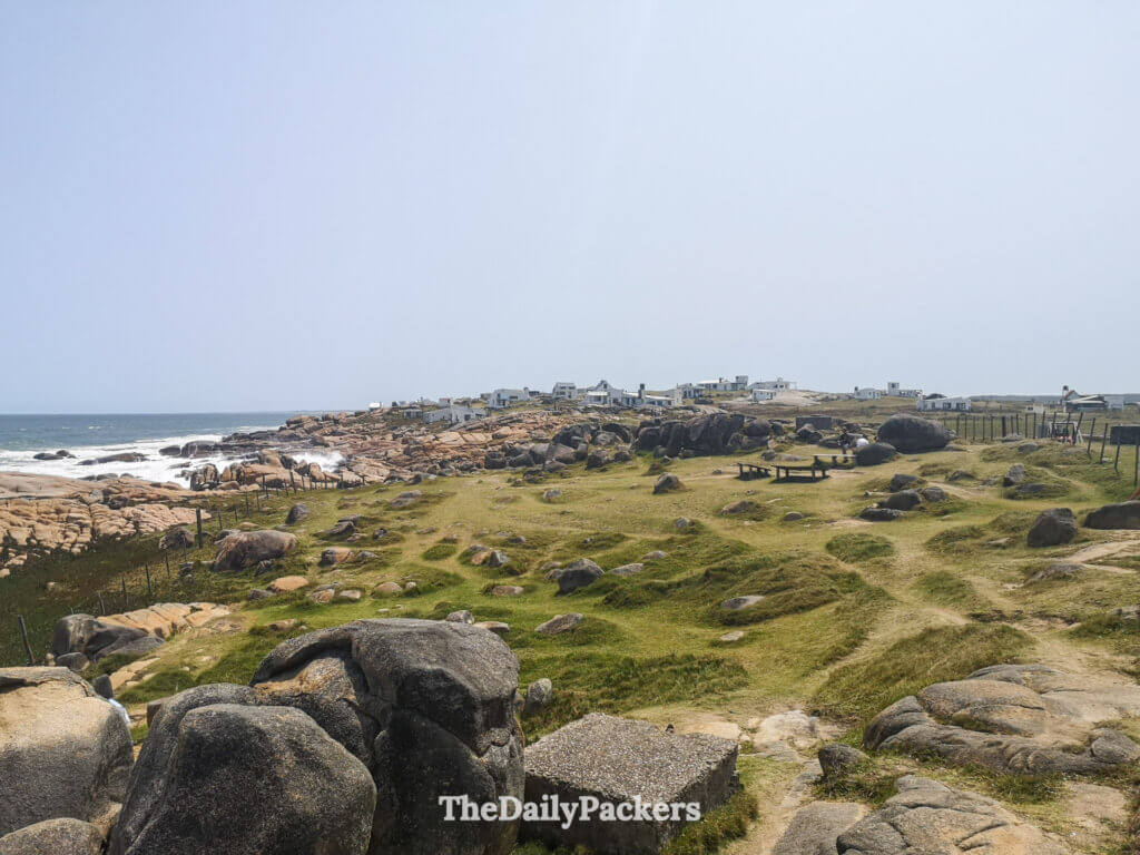 Panoramic view of Cabo Polonio village with rocky shores and white houses by the ocean.