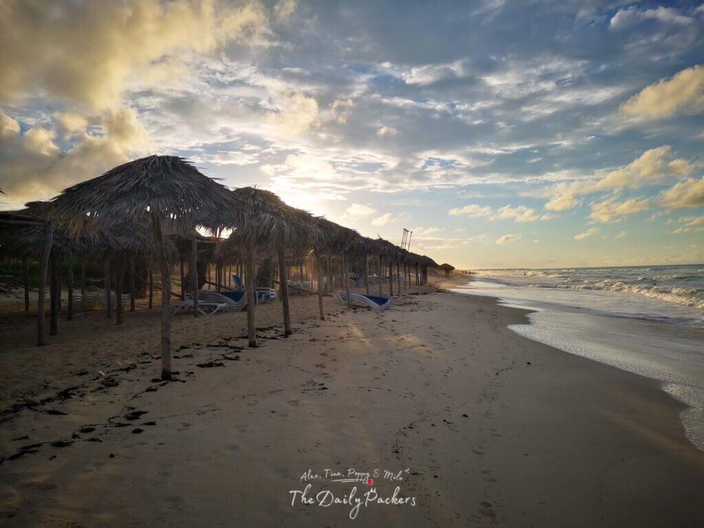 Plage déserte avec palapas et chaises longues au lever du soleil à Cayo Santa Maria, Cuba.