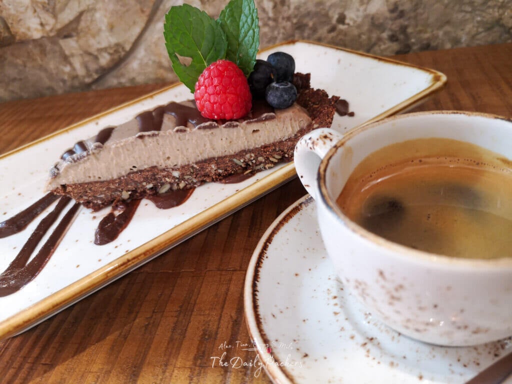 Dessert au chocolat végétalien avec café servi au restaurant Byoko à Málaga, garni de baies et de menthe.