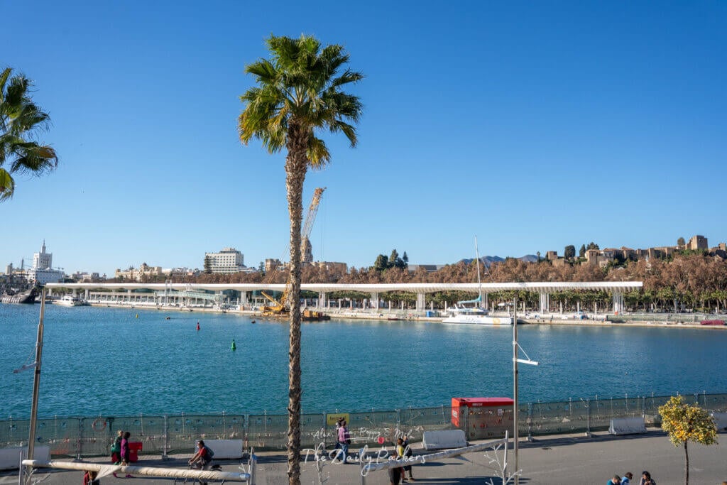 Scenic view of Málaga’s waterfront with palm trees, boats, and the modern Pergolas de la Victoria promenade. A must visit during a Malaga itinerary