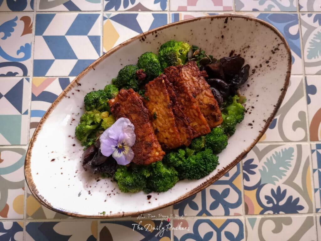 Gros plan d'un bol de ramen végétalien avec du tofu grillé, de la tomate rôtie, des algues et des oignons verts servi au MIMO Vegan Bistrot à Málaga, Espagne.