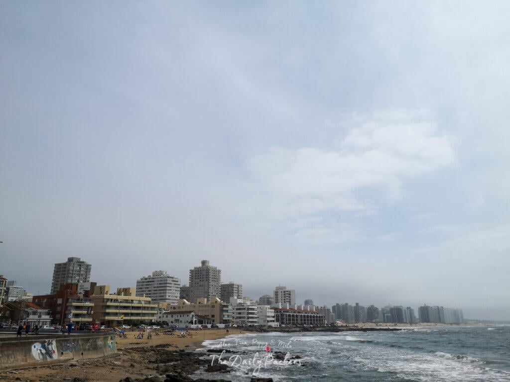 View of Punta del Este’s coastline with sandy beaches, seaside buildings, and waves breaking along the shore.
