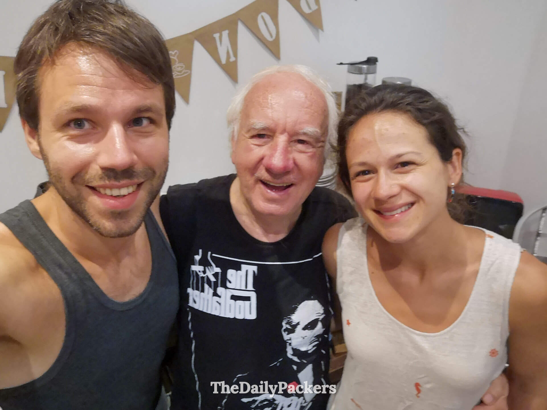 Friendly moment with the hostel owner of a unique guesthouse in Montevideo at Chez Mario, sharing smiles with travelers in the cozy common room