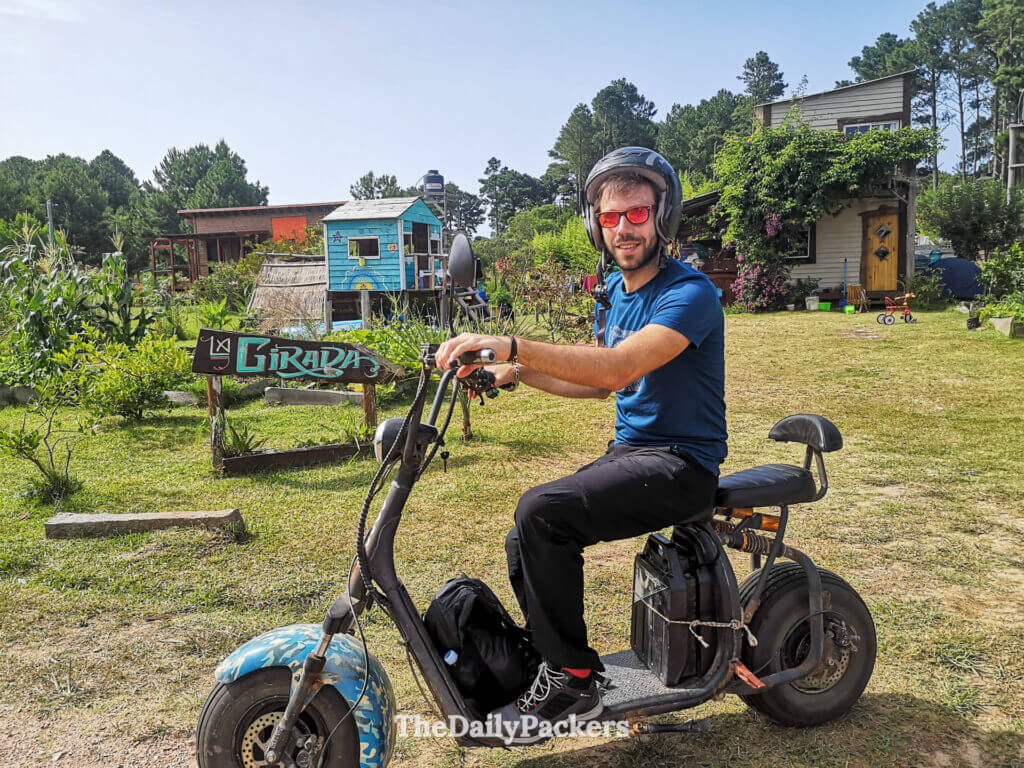 Traveler sitting on an electric scooter at La Girada Eco Camping, ready to explore Punta del Diablo.