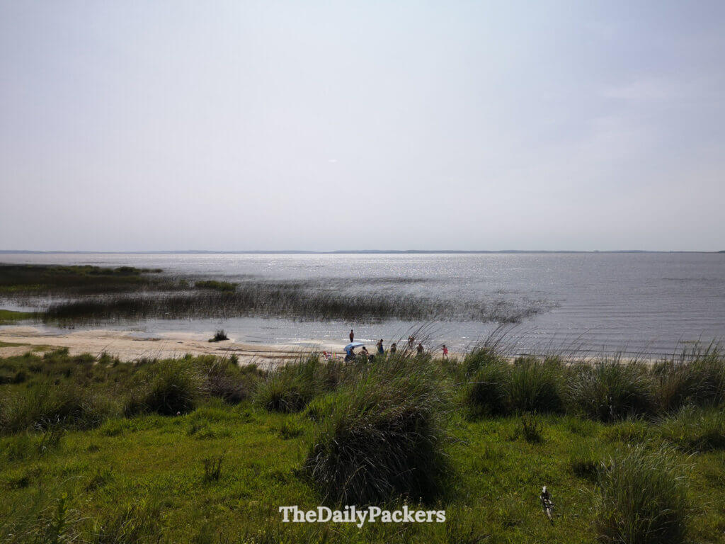 Peaceful view of Laguna Negra, where families enjoy the calm waters and soft sandy shore surrounded by greenery.