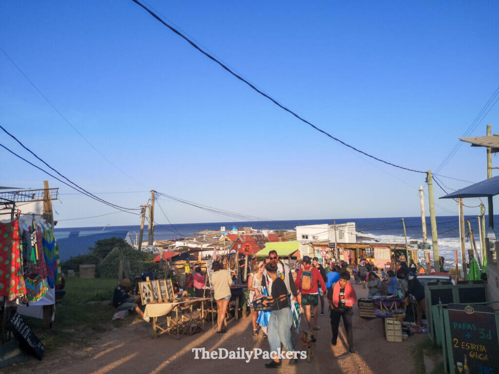 Busy street market in the heart of Punta del Diablo, filled with artisanal stalls, locals, and travelers.