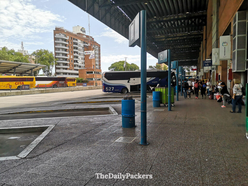 Busy Tres Cruces bus terminal in Montevideo with travelers waiting and buses lined up at the platforms