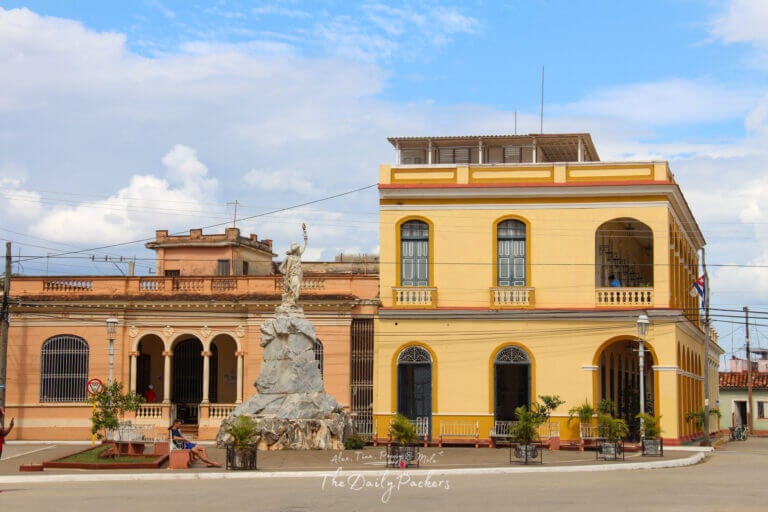 Yellow colonial building and statue at the main square of Remedios, Cuba.
