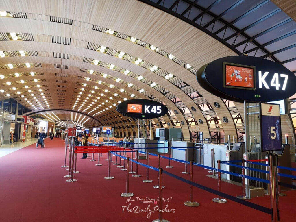 Spacious Air France terminal with red carpet, bright ceiling lights, and boarding gates labeled K45 to K47.