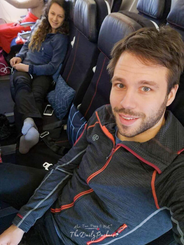 Couple sitting comfortably on an airplane, smiling and relaxed as they prepare for takeoff.