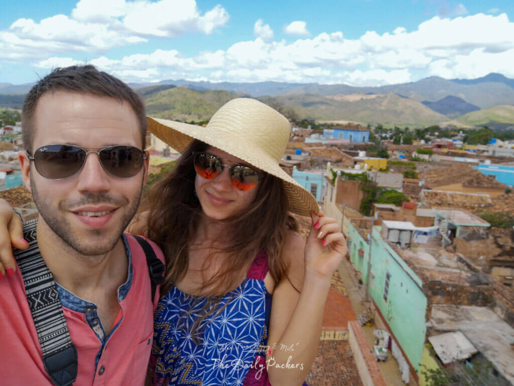 Couple posant au point de vue sur le toit du Palacio Cantero avec une vue panoramique sur Trinidad et les montagnes.