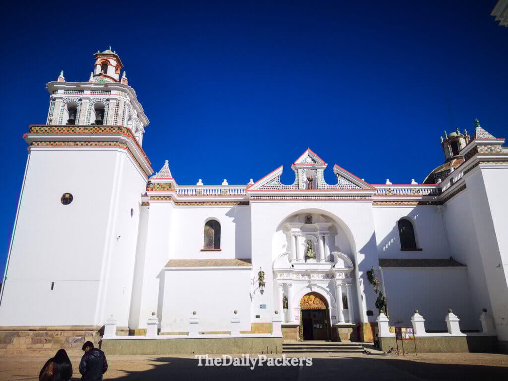 White facade of the Basilica of Our Lady of Copacabana shining under a bright blue sky.