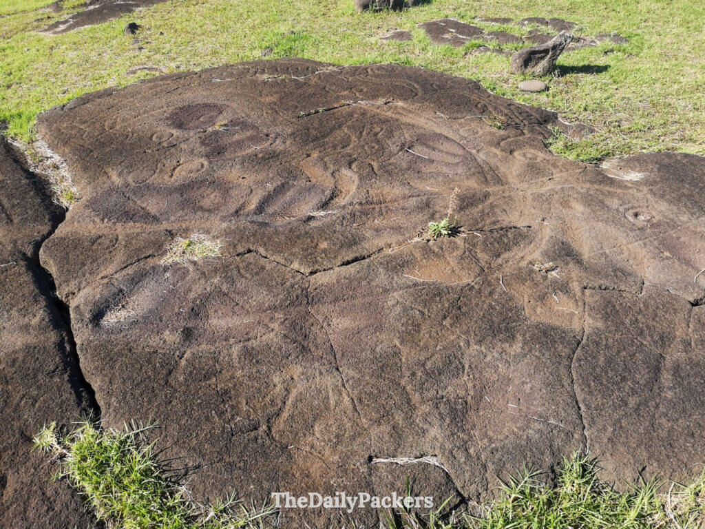 Wide view of the Papa Vaka petroglyph site on Easter Island, showcasing multiple engraved figures spread across a large volcanic rock slab.
