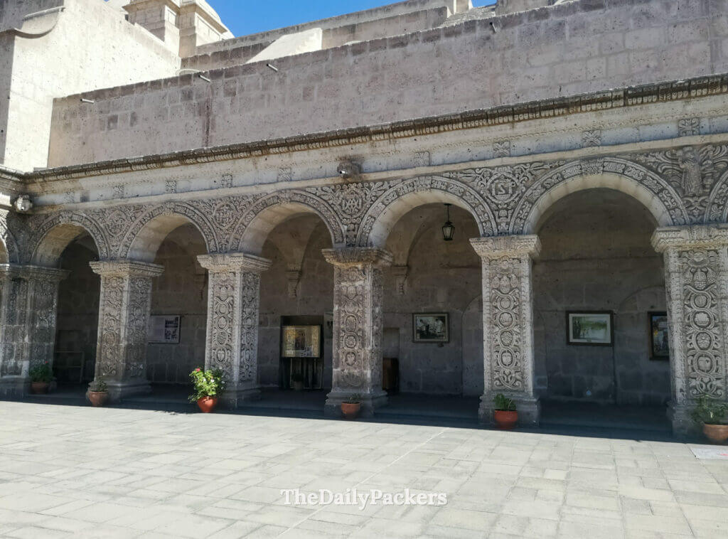 Ornate stone arches of the Church of the Company of Jesus in Arequipa, showcasing intricate baroque carvings in white volcanic sillar