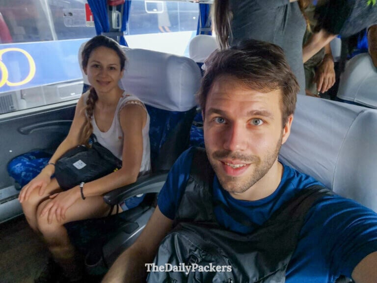 Couple selfie inside a long-distance bus on the Curitiba to Joinville route, documenting the start of their road journey in southern Brazil