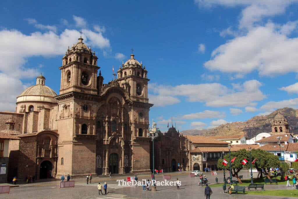 Cusco Cathedral on the Plaza de Armas, displaying its grand colonial architecture and twin bell towers under a bright blue Andean sky.
