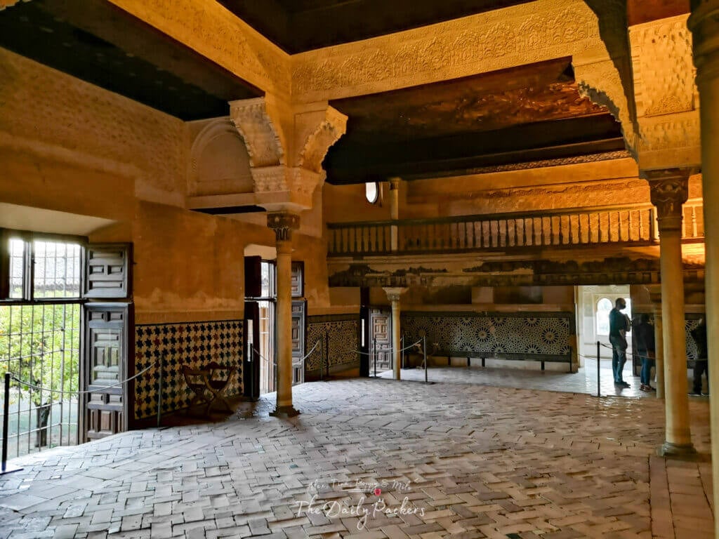Intérieur de la Salle du Mexuar dans les Palais Nasrides de l'Alhambra, présentant des arches mauresques, des détails de stuc sculptés et des carreaux andalous traditionnels.