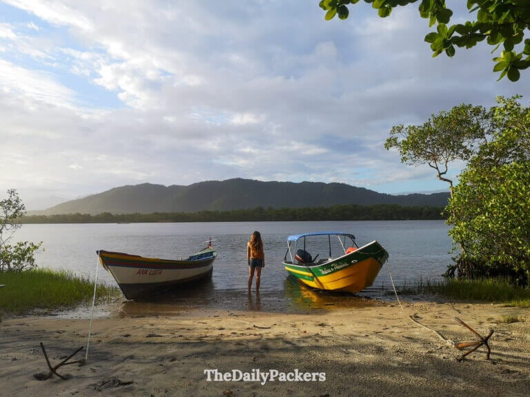 Traditional wooden fishing boats resting on the calm lagoon waters of Ilha do Cardoso, with forested hills in the background