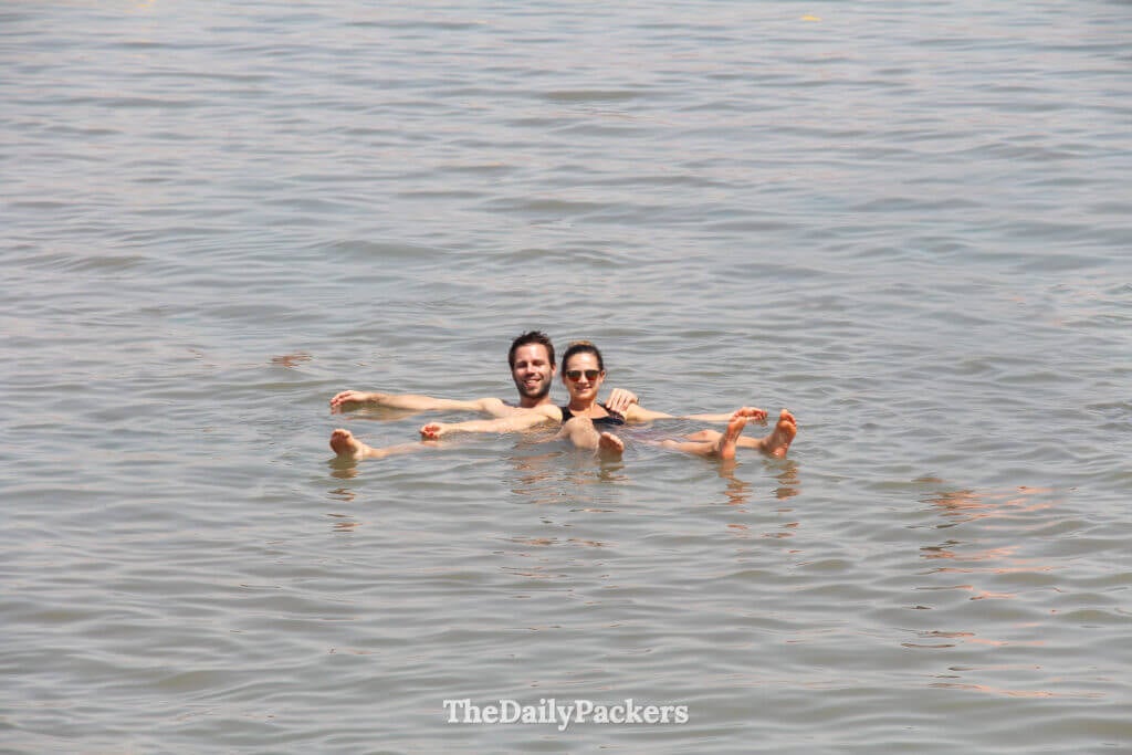 Couple floating on their backs in the Dead Sea, enjoying the unique buoyancy and tranquil atmosphere