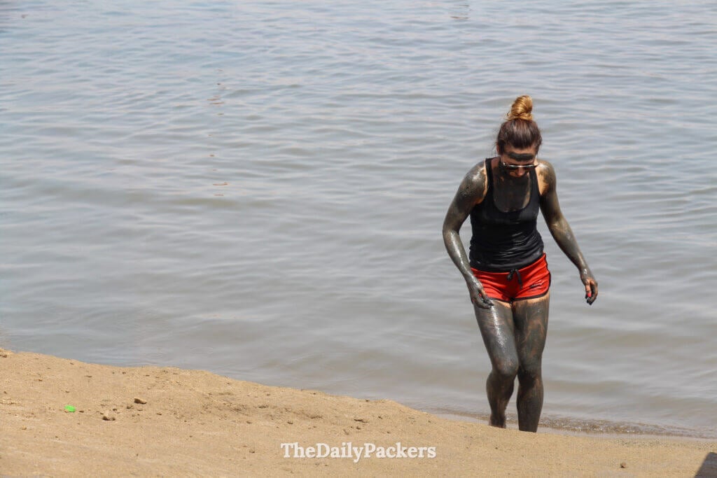 Visitors covered in mineral-rich Dead Sea mud on the shoreline, a popular wellness experience known for its natural skin benefits