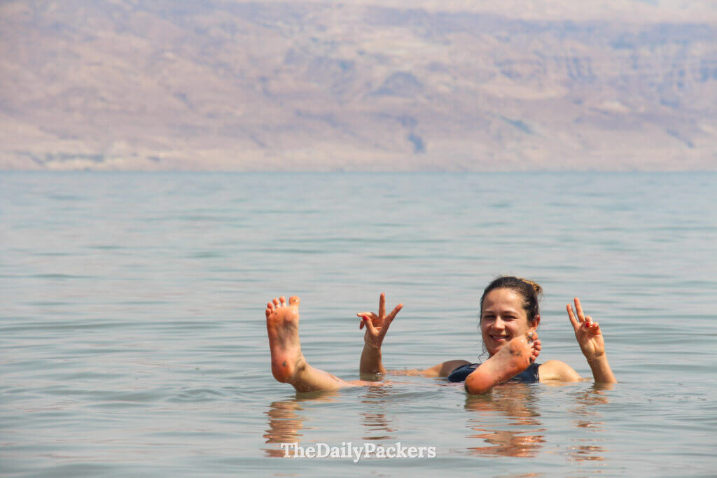 Woman floating calmly on the Dead Sea with mountains in the background, enjoying the unique natural phenomenon