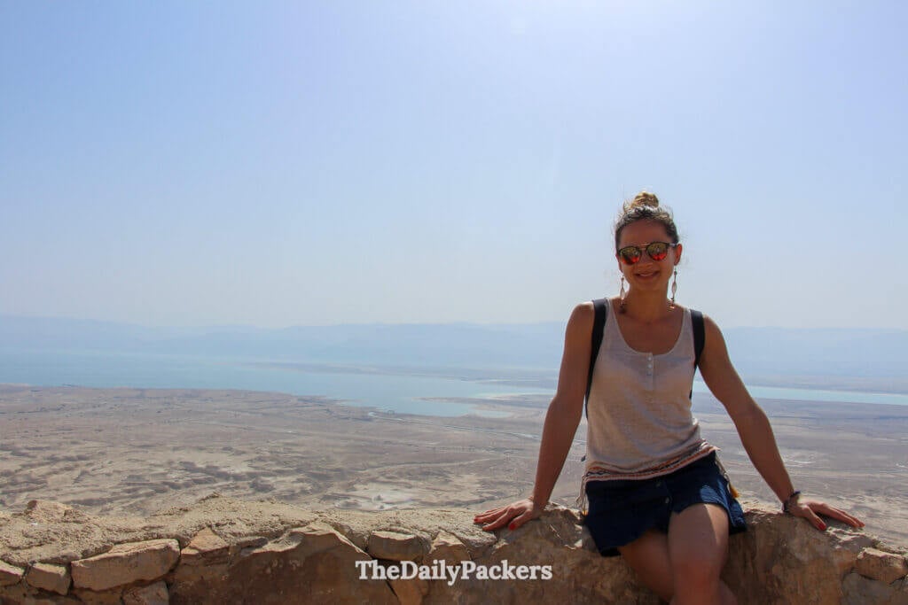 Traveler standing at Masada with sweeping views of the Judean Desert and rugged canyon landscape