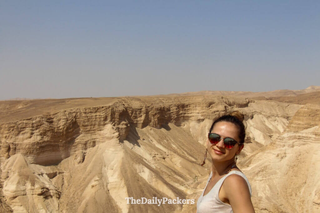 Traveler posing at Masada fortress with panoramic views of Israel’s desert landscape and steep surrounding cliffs