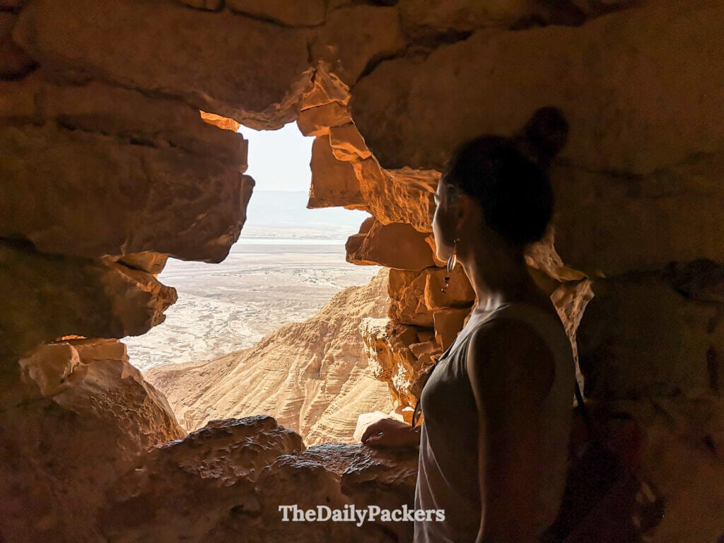 View through a stone opening in Masada’s walls framing the vast desert landscape and arid terrain below