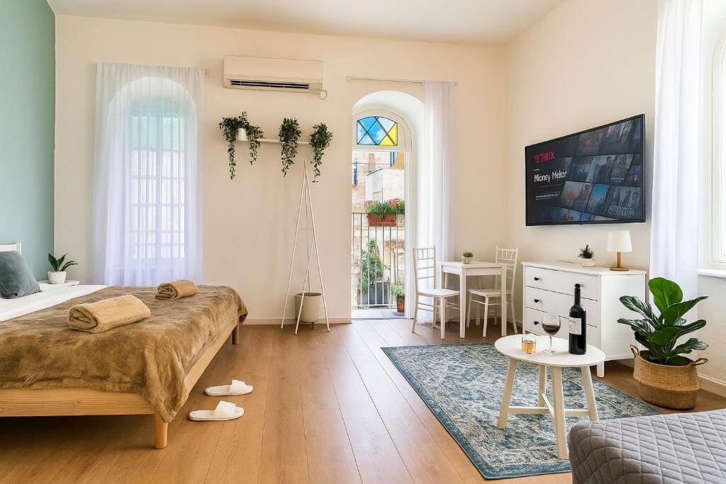 Modern boutique hotel room near Mamilla Mall in Jerusalem featuring a bright interior, balcony doors, and city views