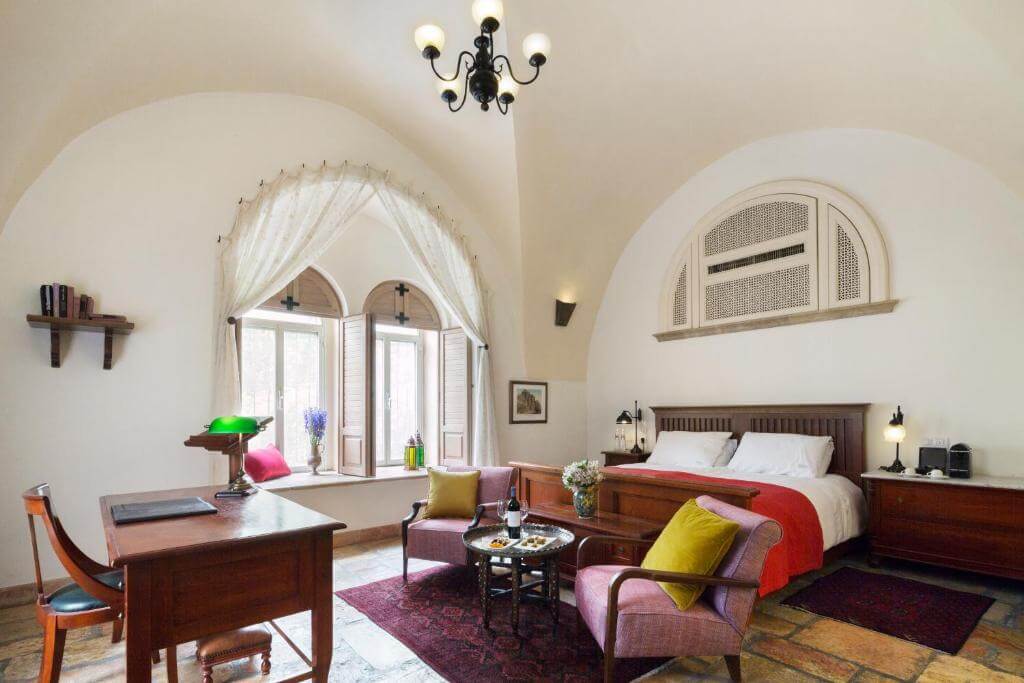 Elegant historic room at the American Colony Hotel in Jerusalem with arched ceilings, antique furniture, and classic decor