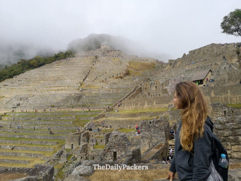 Traveler looking out over Machu Picchu’s terraced ruins, with the ancient Inca city and surrounding misty mountains visible in the background during a 3 weeks south america itinerary