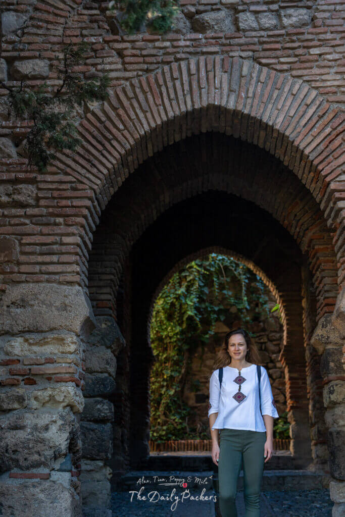 Détail des arches de style mauresque à l'intérieur de l'Alcazaba de Málaga, avec des briques superposées et une douce lumière naturelle illuminant le passage historique.