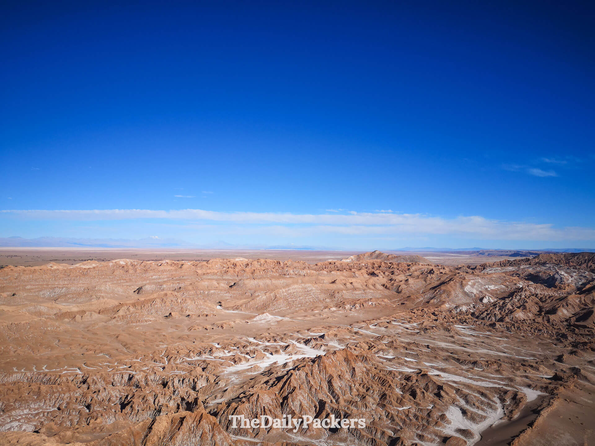 Panoramic desert landscape from Likan Antay viewpoint in Valley of the Moon, highlighting rugged rock formations and the salt-crusted terrain typical of the Atacama Desert.