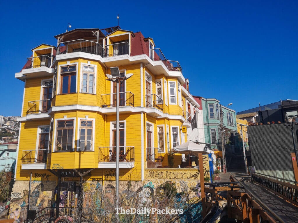 Maison patrimoniale jaune vif sur le Paseo Dimalow dans Cerro Alegre, Valparaíso, avec son architecture classique en bois surplombant les collines de la ville.