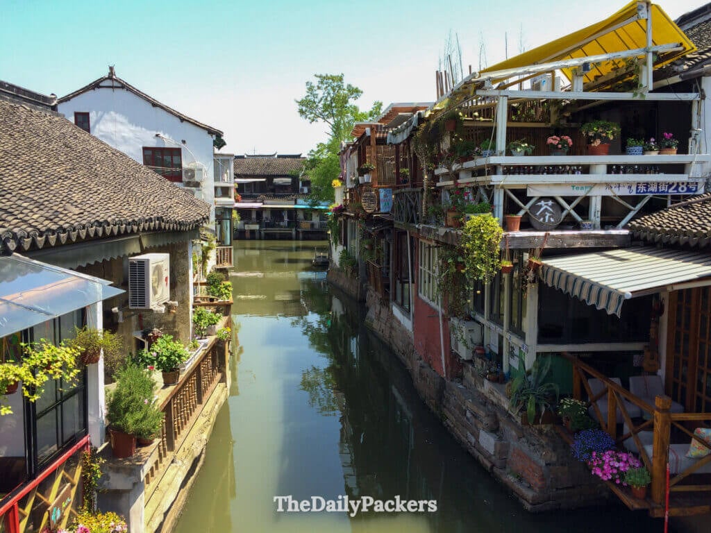 Scène de canal paisible avec des reflets de maisons historiques et de verdure à Zhujiajiao, Shanghai