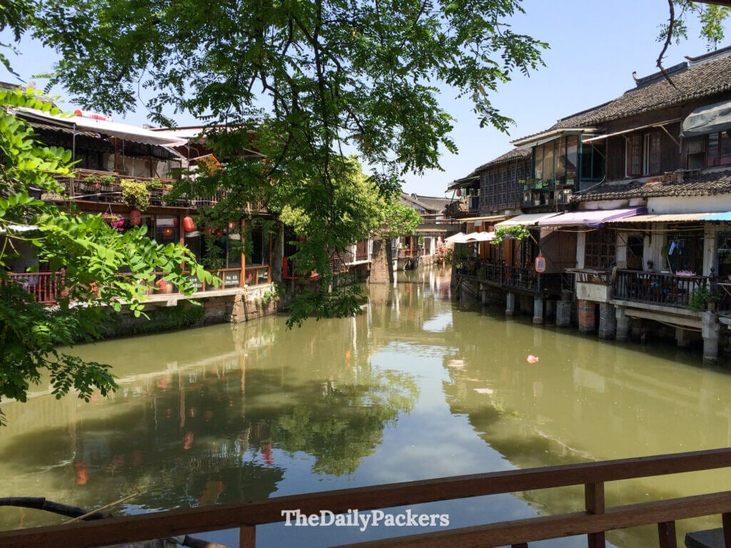 Intersection de canaux entourée de bâtiments riverains traditionnels et de cafés à Zhujiajiao, en Chine